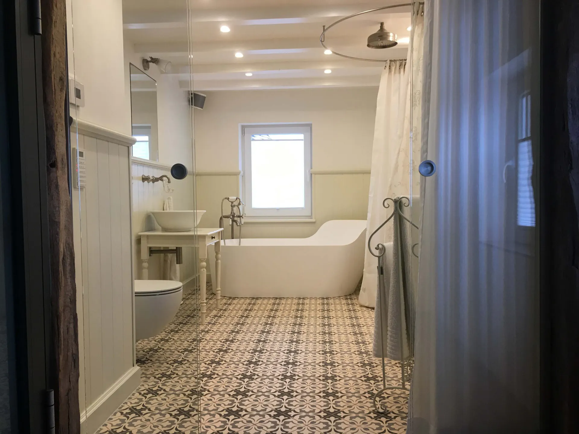 Saniertes Badezimmer mit freistehender Badewanne und Ornamentfliesen