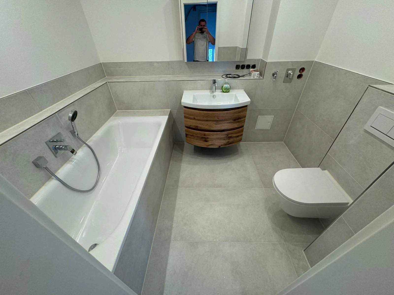 Saniertes Badezimmer mit Badewanne, Holzwaschtisch und WC