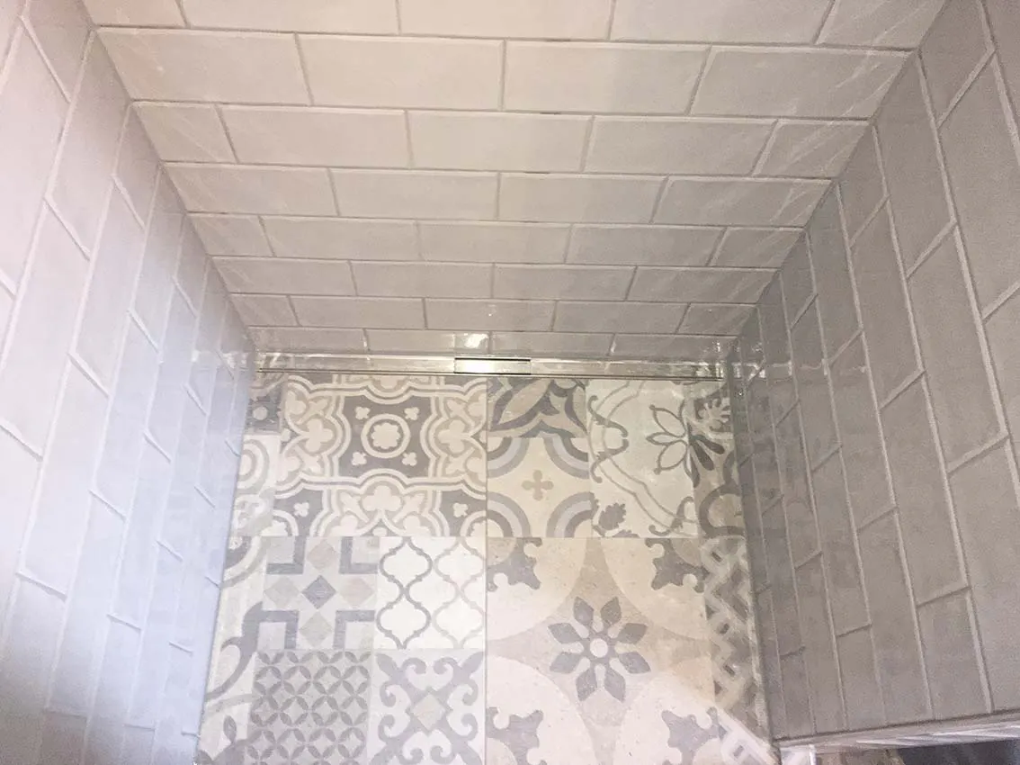 Sanierte Dusche mit gemusterten Vintagefliesen