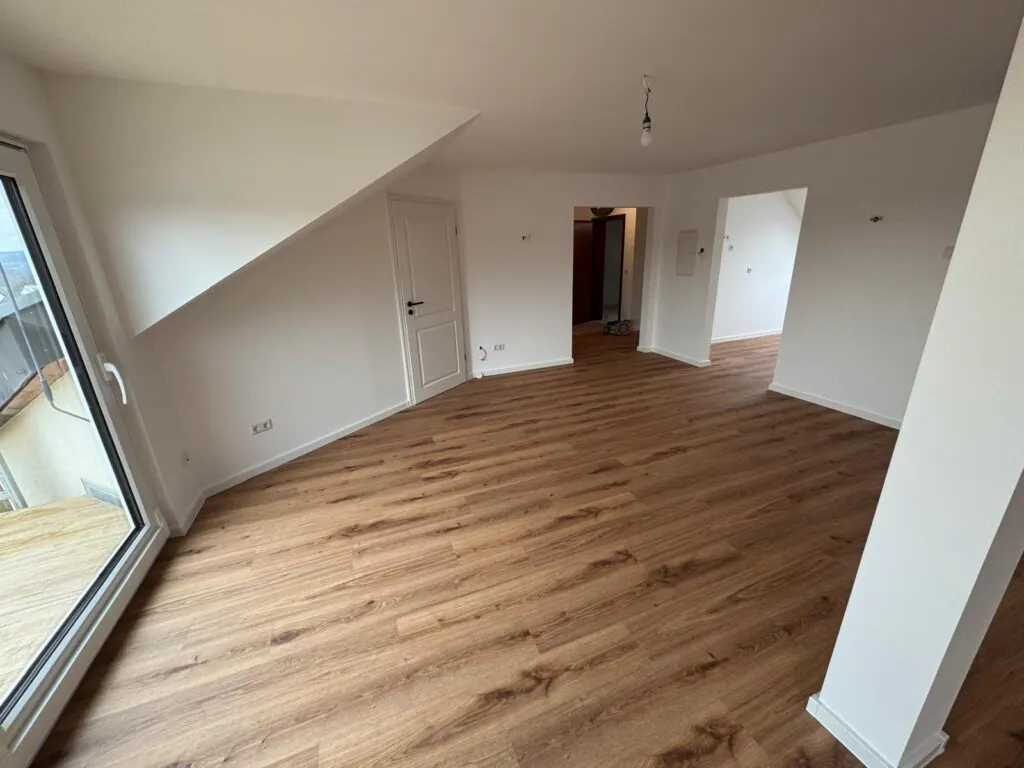 Komplett sanierter Wohnbereich mit neuem Boden und weißen Wänden