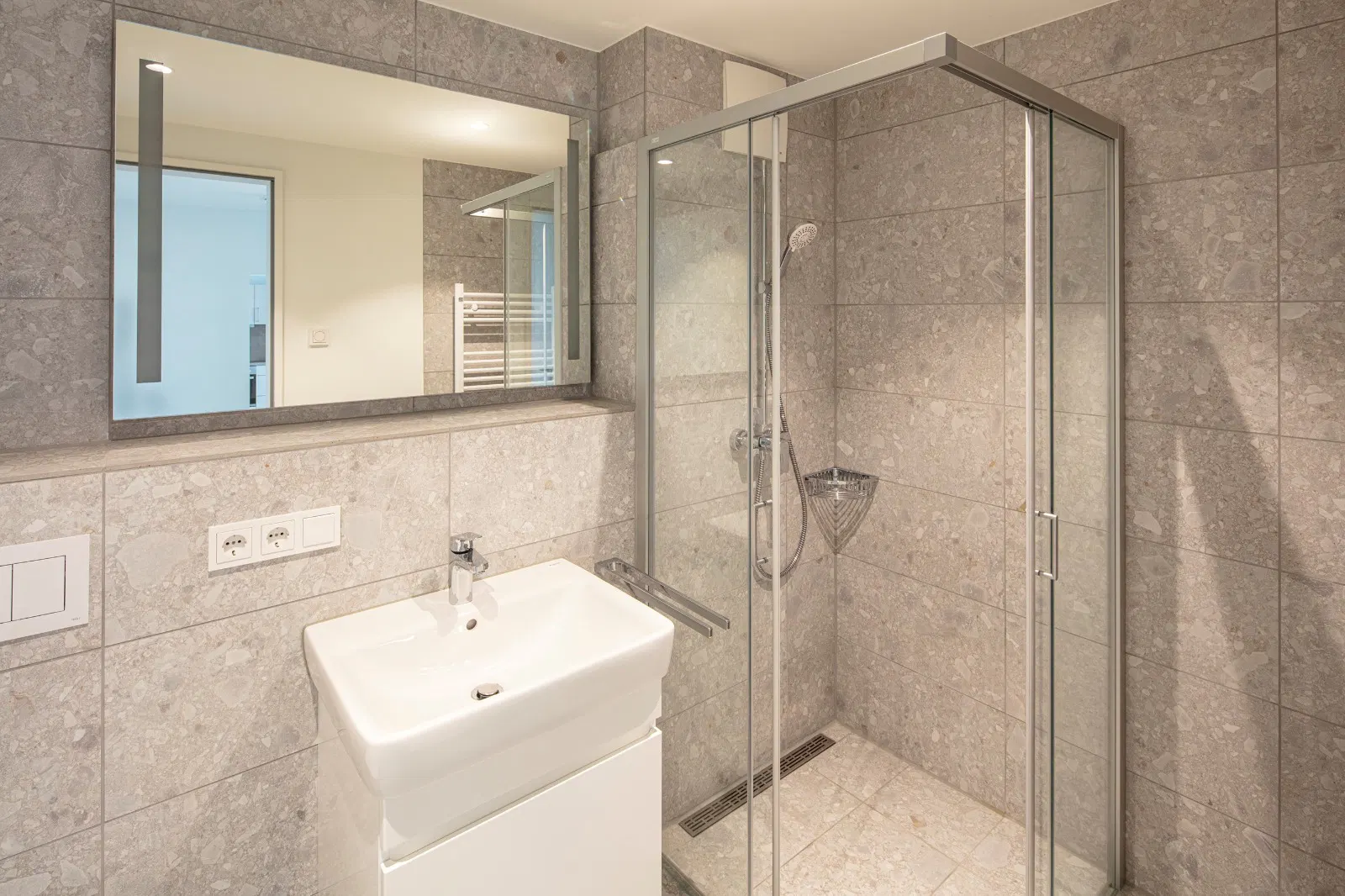 Modernes Badezimmer im Quartier im Reitstall mit großformatigen grauen Fliesen