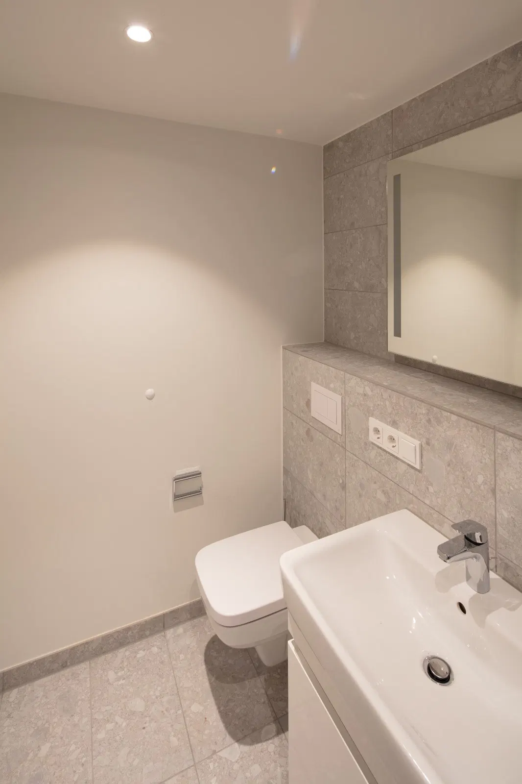 Waschtisch und WC-Bereich im Quartier im Reitstall mit keramischen Wand- und Bodenflächen