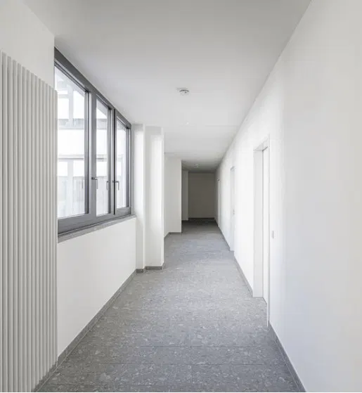 Flurbereich im Quartier im Reitstall mit hellen Wänden und grauem Bodenbelag